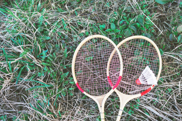 istock White shuttlecock and badminton racket lying on green grass 1064285556
