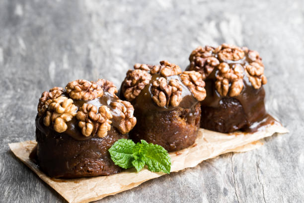 istock Sticky chocolate and walnut puddings on wooden table 1064286354