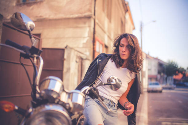 istock Young pretty fashioned girl sitting on her motorcycle 1064287590