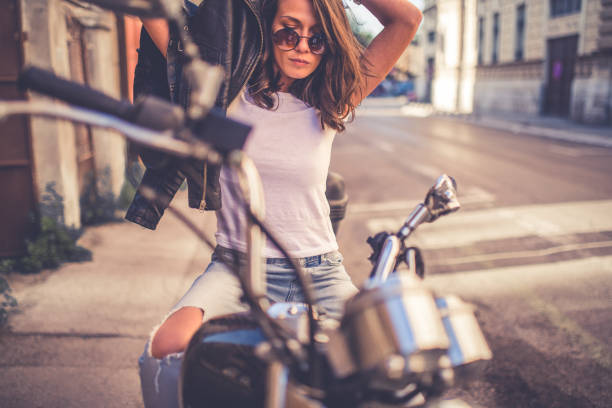 istock Young pretty fashioned girl sitting on her motorcycle 1064287778