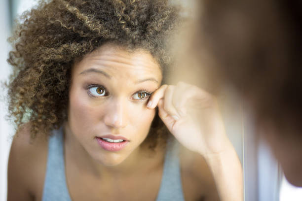 istock Pretty afro haired woman checking her makeup in the mirror 1064288202
