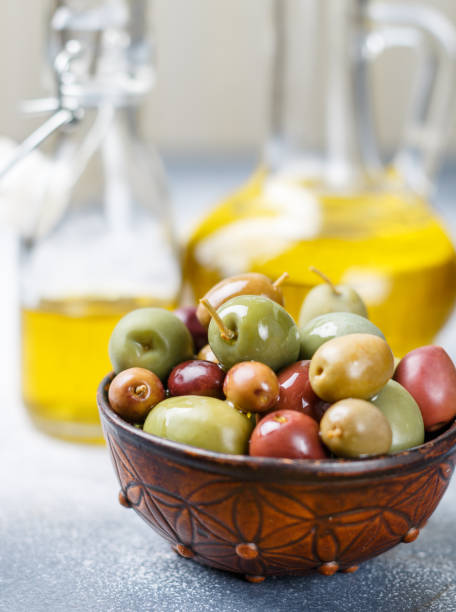 istock Mixed marinated olives (green, black and purple) in ceramic bowl  and olive oil 1064289312