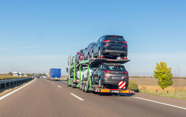 reboque de carro transportador com novos carros para venda na plataforma de beliche na estrada - car freight transportation new traffic - fotografias e filmes do acervo