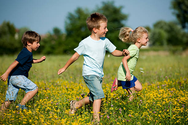 istock Three children running through a field of grass  106429401