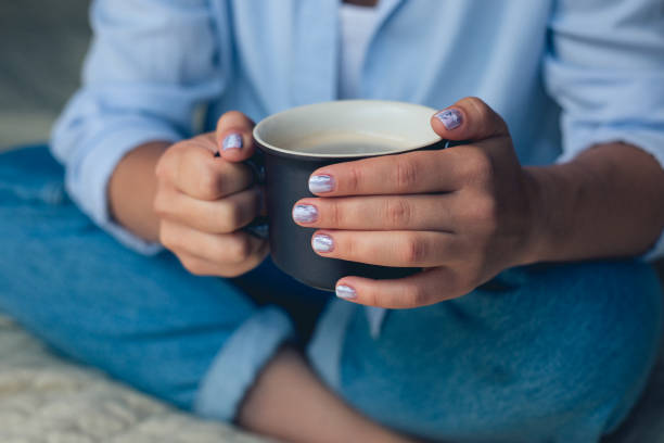 istock Cute girl with a beautiful manicure drinking coffee 1064294212