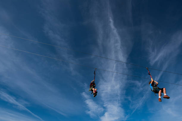 istock Children zip lining across a beautiful blue sky 1064294608