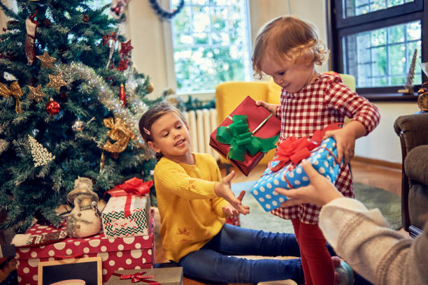 istock two sisters exchanging Christmas gifts 1064297892