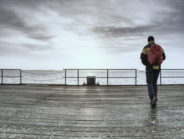 istock Man with backpack walking by bridge near the river 1064298260