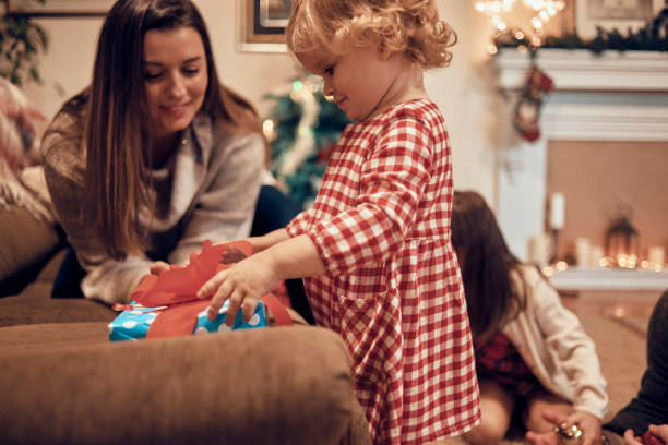 istock cute little girl opening her Christmas present 1064301206