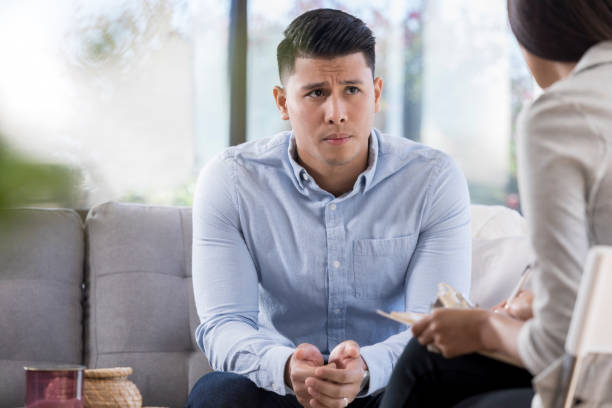 istock Concerned young man talking with counselor 1064312718