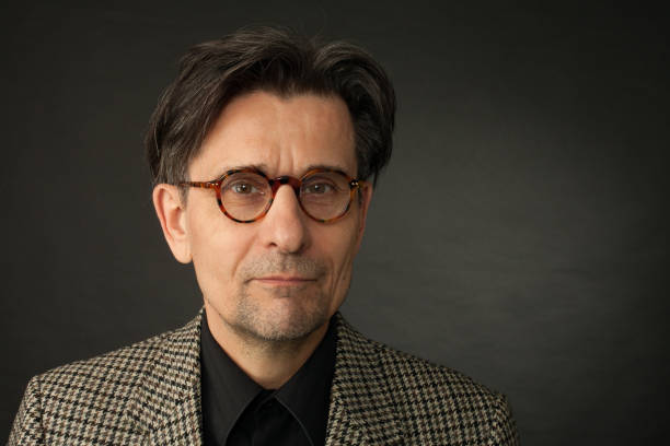 studio portrait of 60 year old man on black background