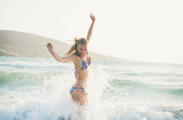 giovane donna che gode di acque calde del mar mediterraneo, grecia - sea swimming greece women foto e immagini stock