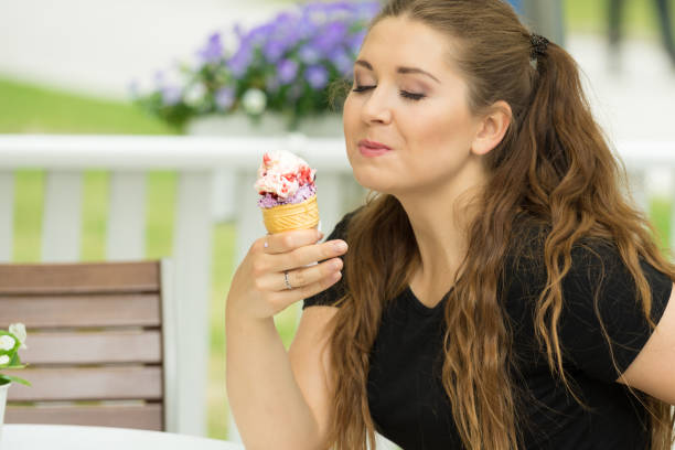 istock Young woman eating ice cream 1064325508