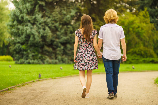 istock Couple walking holding hands in park 1064327488