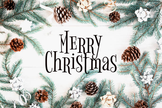 istock Christmas composition, frame. Fir branches, cones, gold and silver bows lie in a circle. In the center of the inscription Merry Christmas. Holiday photography on a light wooden background. 1064332914