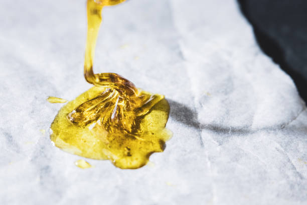 THC concentrated wax isolated up close on non-stick paper THC concentrated rosin dripping on wax paper rosin stock pictures, royalty-free photos & images