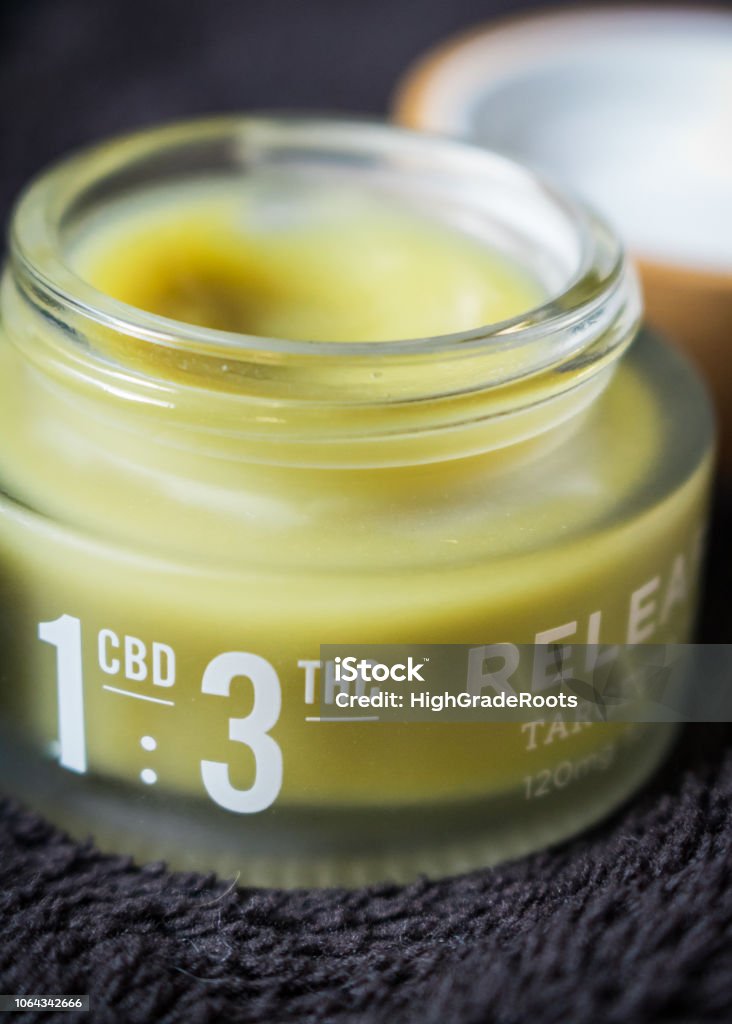 Open container of cannabis infused balm for pain relief THC/CBD relief balm Moisturizer Stock Photo