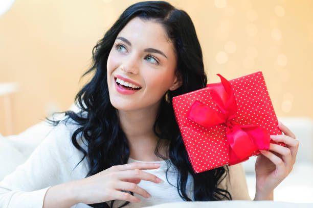 istock Young woman holding a gift box 1064344034