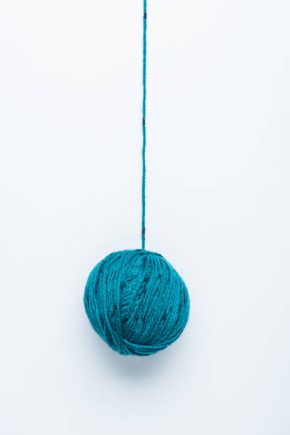 A small ball of light blue yarn isolated on a white background