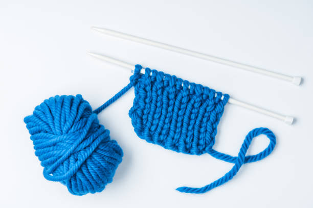 istock top view of blue yarn and knitting needles on white backdrop 1064344698