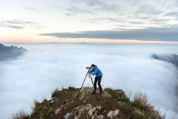 Anonymous silhouette of photographer overlooking a blanket of fog over Pacific Ocean and the Santa Cruz Mountains in California