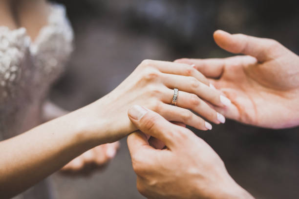 Man tenderly put on ring on woman hand