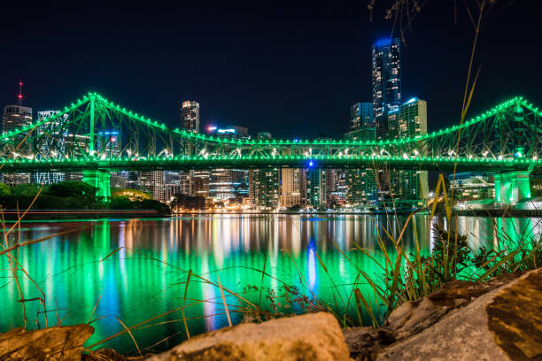 istock Rocks on shore with cityscape in night 1064353764