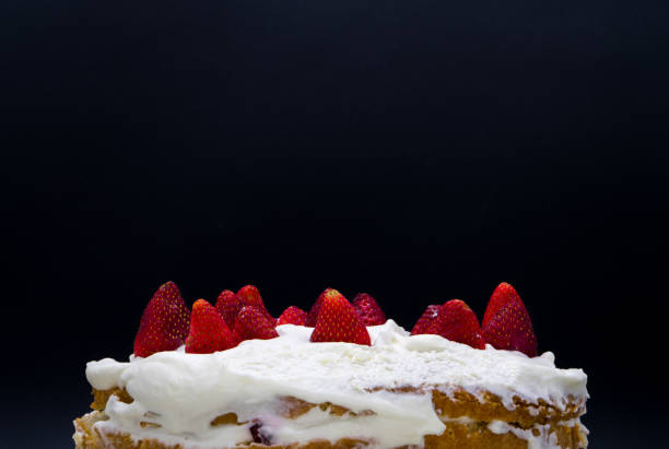 istock Organic strawberry cake with whipped cream isolated on a black background 1064359106
