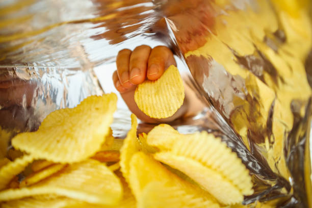 istock Hand hold potato chips inside snack foil bag 1064370686