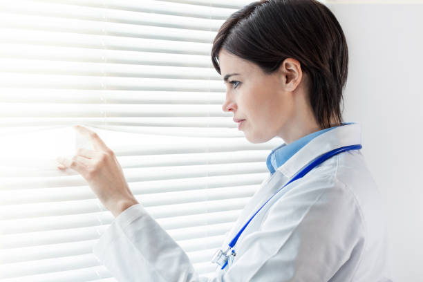 istock Young doctor or nurse looking through a window 1064370754