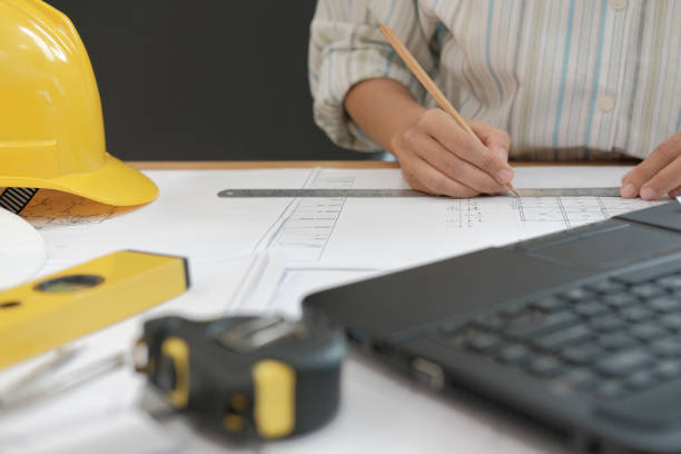 istock architect engineer working on house blueprint of real estate project at workplace. building construction concept 1064371138