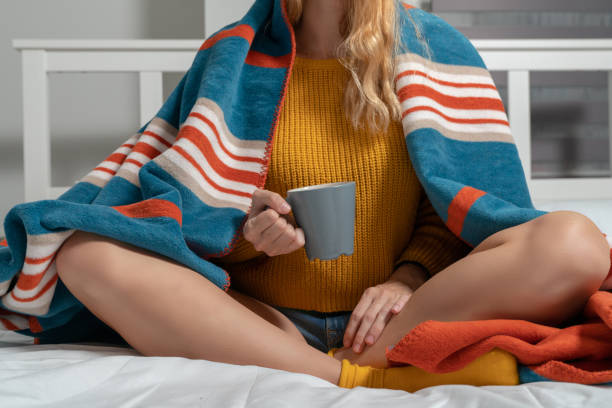 istock young woman chilling in cold room drinking coffee in bed 1064372258