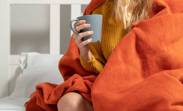 istock young woman chilling in cold room drinking coffee in bed 1064372264