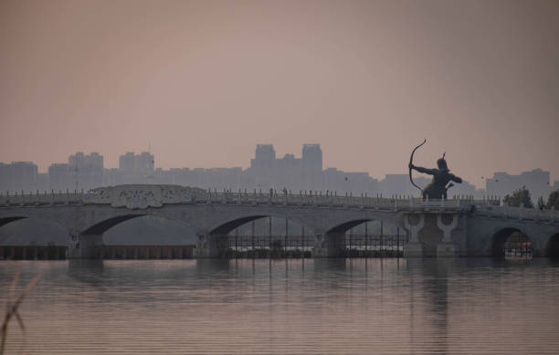 istock beautiful Wuhan in sunset and ancient statue.  And with the arch bridge. 1064377722