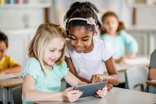 istock Two Young Girls in a Classroom using a Tablet 1064378244