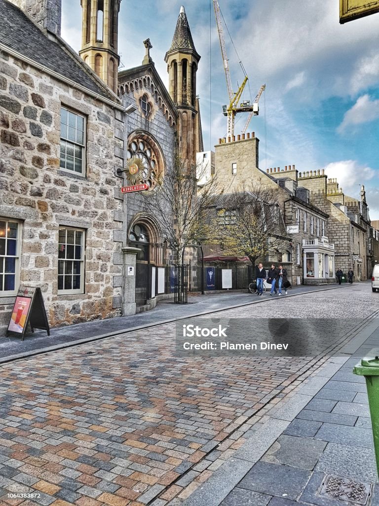 Aberdeen city centre Church, stone buildings, group of lads, construction crane blue sky Aberdeen - Scotland Stock Photo