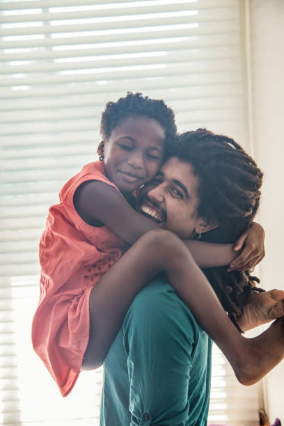 istock Cute little girl cuddled up on her dad like a monkey while he smiles at camera 1064385332