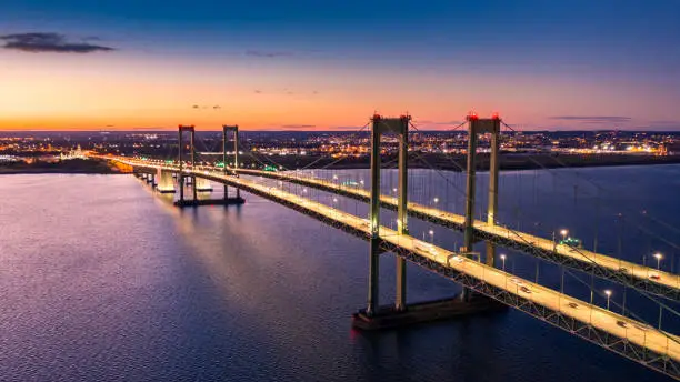 Aerial view of Delaware Memorial Bridge at dusk. The Delaware Memorial Bridge is a set of twin suspension bridges crossing the Delaware River between the states of Delaware and New Jersey