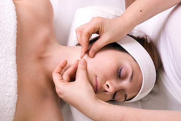 massaggio del viso - massaging facial massage beautician beauty treatment foto e immagini stock