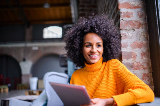 Smiling woman using digital tablet. Smiling Brazilian  woman using digital tablet. modern lifestyle stock pictures, royalty-free photos & images