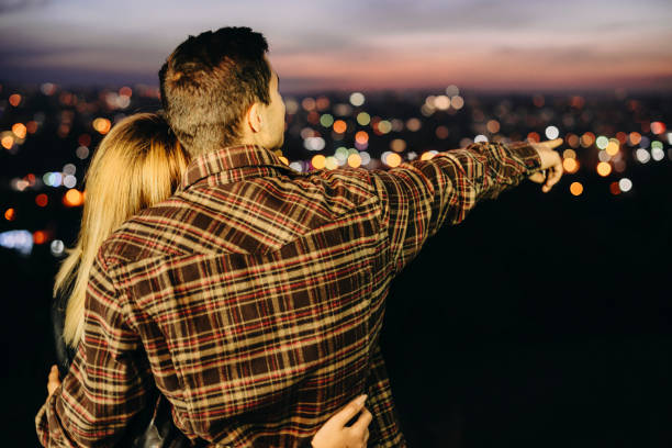 istock Anonymous couple looking at night city 1064410456