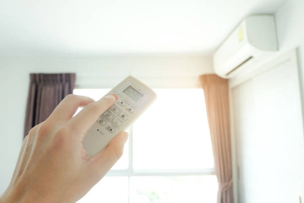 istock Man's hand using remote control open The air conditioner is cooled to 25 degrees Celsius in his bedroom. Health concepts and energy savings 1064412704