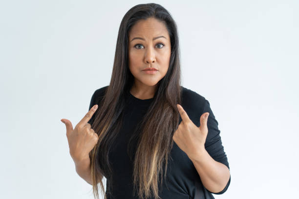 istock Surprised black-haired woman pointing at herself 1064428210