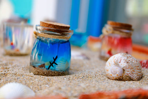 bottle of water and sand on the sand beach - shell sea souvenir island imagens e fotografias de stock