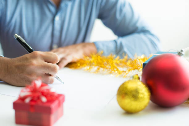 紙にメモをする認識で��きない人間のクローズ アップ - christmas ball christmas ornament human hand ストックフォトと画像