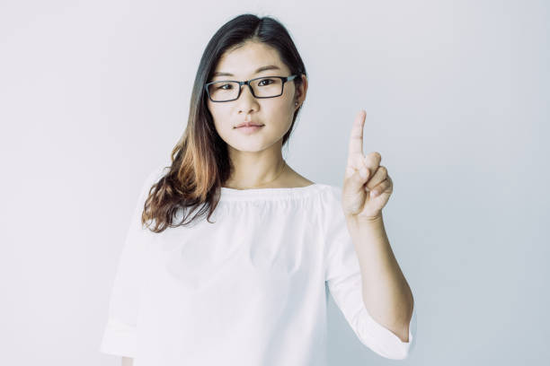 istock Confident well-educated young woman showing index finger 1064433768