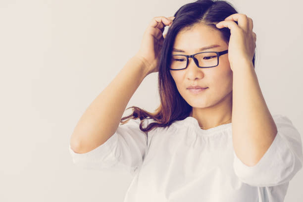 istock Pensive young Asian woman touching head and thinking of problem 1064433794