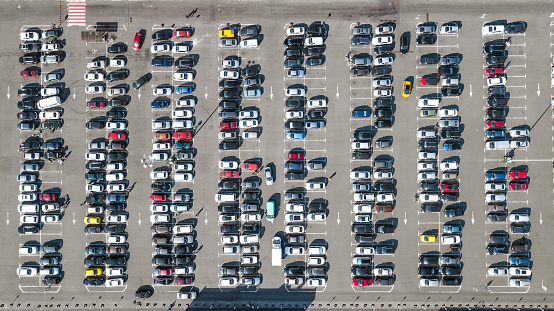 Aerial drone view of parking lot with many cars from above, city transportation and urban concept