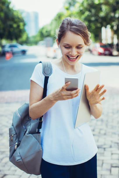 istock Happy female student walking and enjoying mobile message 1064445322