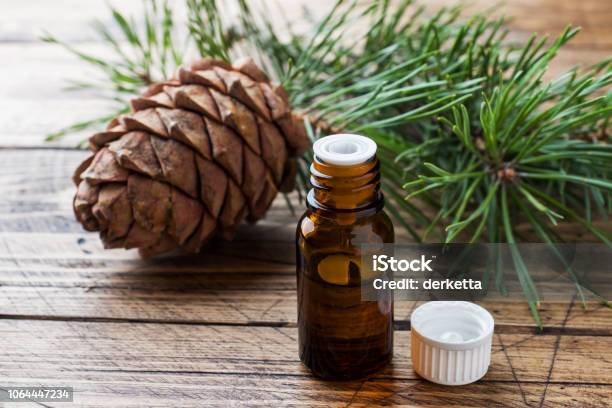 Cedar And Spruce Essential Oil In Small Glass Bottles On Wooden Background Selective Focus Stock Photo - Download Image Now